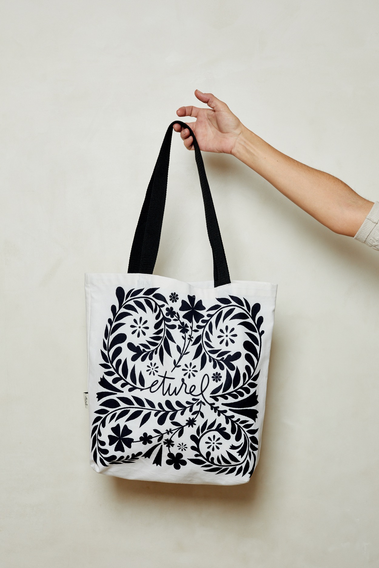 Colección textil de Eturel con ilustraciones florales aplicadas a bolsos, cestas, manteles y caminos de mesa inspirados en los refajos manchegos.