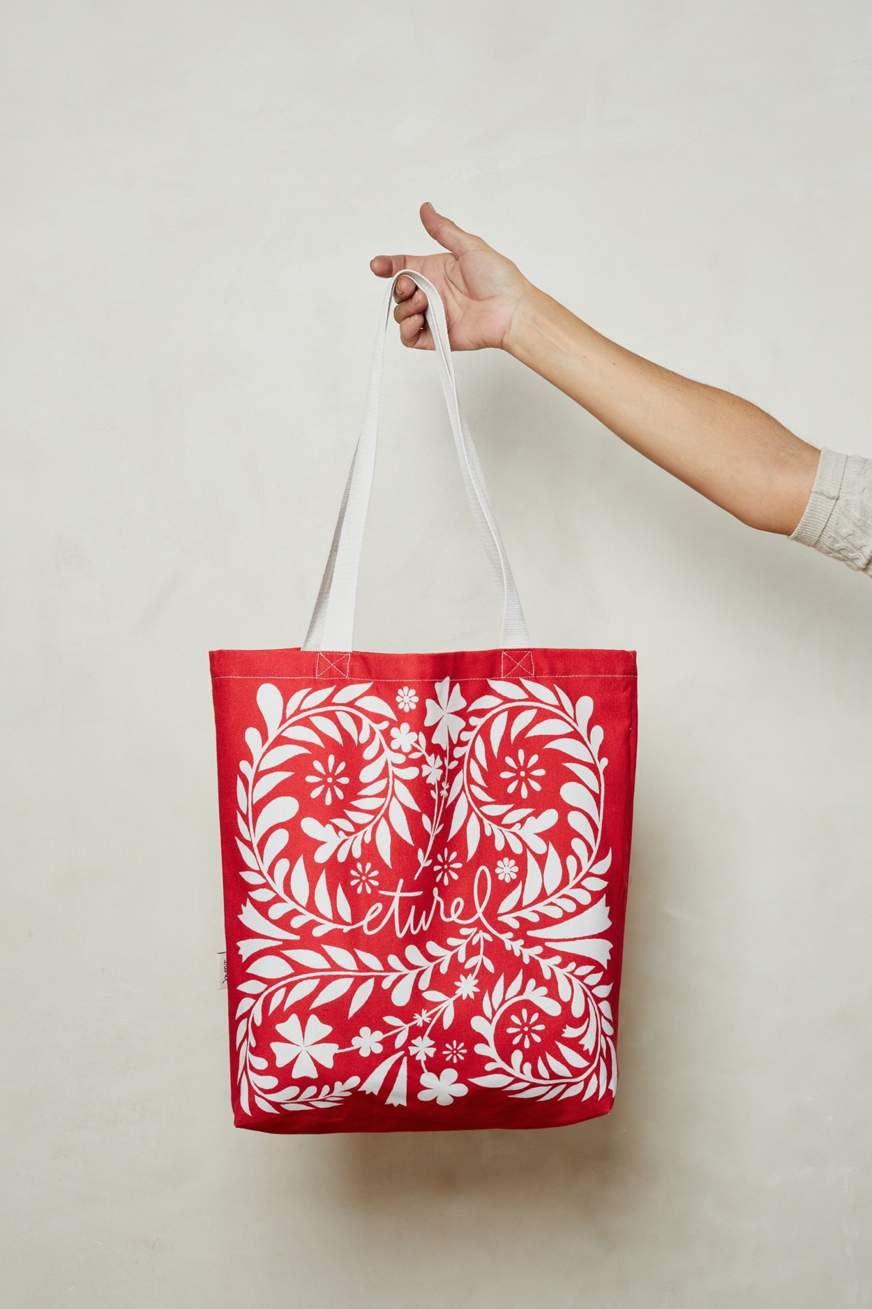 Colección textil de Eturel con ilustraciones florales aplicadas a bolsos, cestas, manteles y caminos de mesa inspirados en los refajos manchegos.