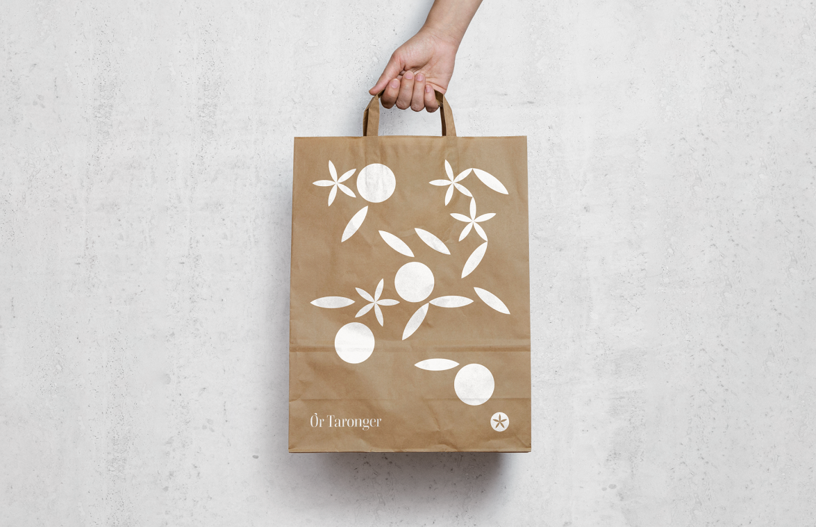 Bolsa de papel kraft con impresión blanca del sistema gráfico de Or Taronger, combinando naturalidad y presencia de marca sostenible.