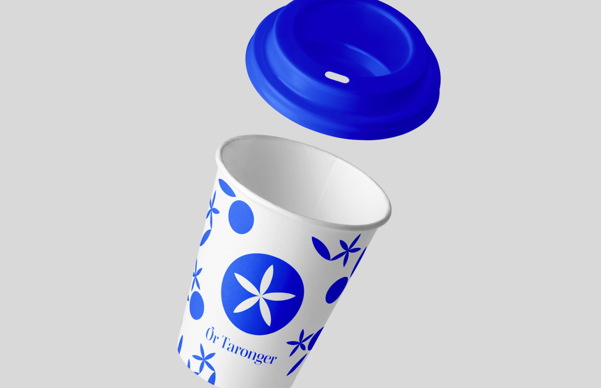 Vaso de café reutilizable con patrón gráfico de Or Taronger en azul y blanco, aplicando el sistema visual modular de la marca.